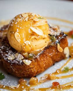 Dessert maison avec glace à la vanille, amandes effilées et caramel sur une base de brioche dorée