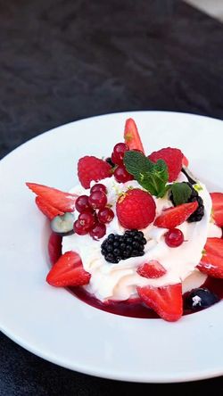 Dessert avec chantilly et fruits rouges frais, présenté dans une assiette blanche au Garden Ice Café Périgueux.