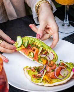 Tarte fine garnie d'avocat, saumon, tomates, radis et concombres, dans un restaurant avec cuisine faite maison.