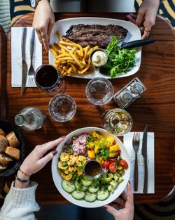 Plat principal de viande avec frites, salade et un bol de légumes frais, service en brasserie.