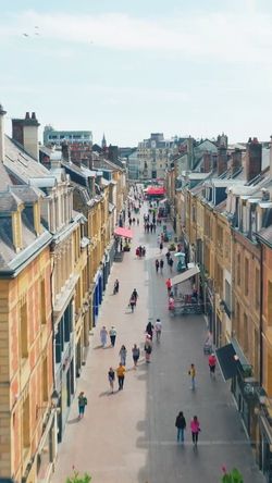 Rue piétonne animée à Brive-la-Gaillarde avec des bâtiments anciens et une brasserie terrasse visible.