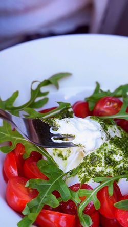 Salade avec tomates cerises, roquette et fromage frais assaisonné d'une sauce pesto verte, plat maison Garden Ice Café.