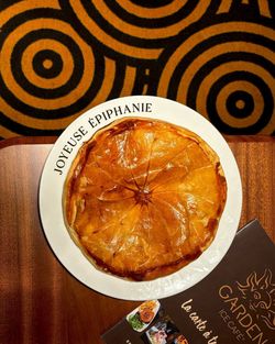 Galette des rois bien dorée présentée sur une assiette avec inscription Joyeuse Épiphanie au Garden Ice Café.