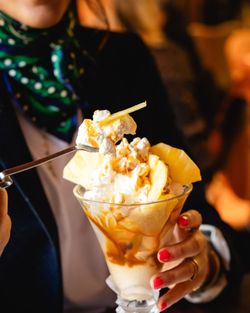 Un dessert glacé avec de la crème chantilly, des morceaux d'ananas et un coulis sur un fond crémeux.