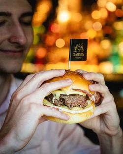 Burger avec viande et fromage dans une brioche, servi avec un petit drapeau Garden Ice Café Orléans planté dessus