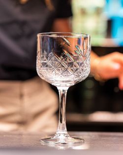 Verre à vin gravé sur un comptoir dans une brasserie à Brive la Gaillarde avec ambiance de terrasse en arrière-plan.