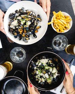 Moules accompagnées de frites et boissons sur table dans une brasserie à Brive-la-Gaillarde.
