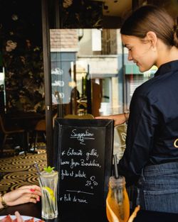 Suggestion de plat avec écriture au tableau noir, boissons à côté, ambiance de café.