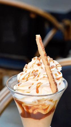 Dessert glacé avec crème fouettée, caramel et biscuit, présenté dans un verre transparent au Garden Ice Café.