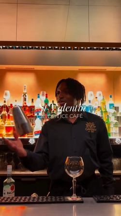 Un barman à l'œuvre, réalisant des cocktails dans un bar bien approvisionné au Garden Ice Café.