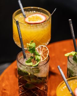Verres décorés de cocktails colorés avec glaçons, menthe fraîche et tranches de fruits au Garden Ice Café à Brive la Gaillade