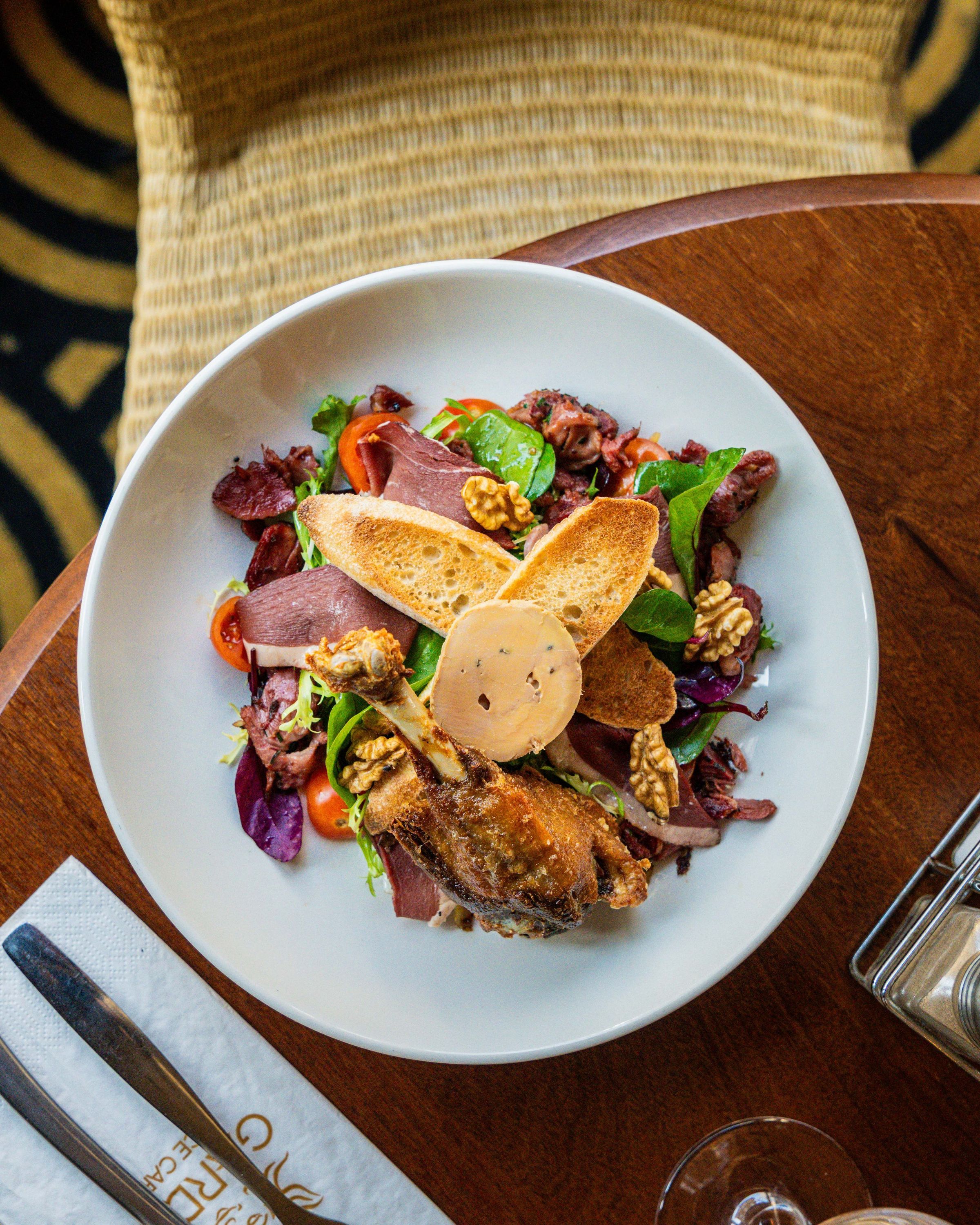 Salade composée avec viande, légumes frais, noix et pain, servie au Garden Ice Café.