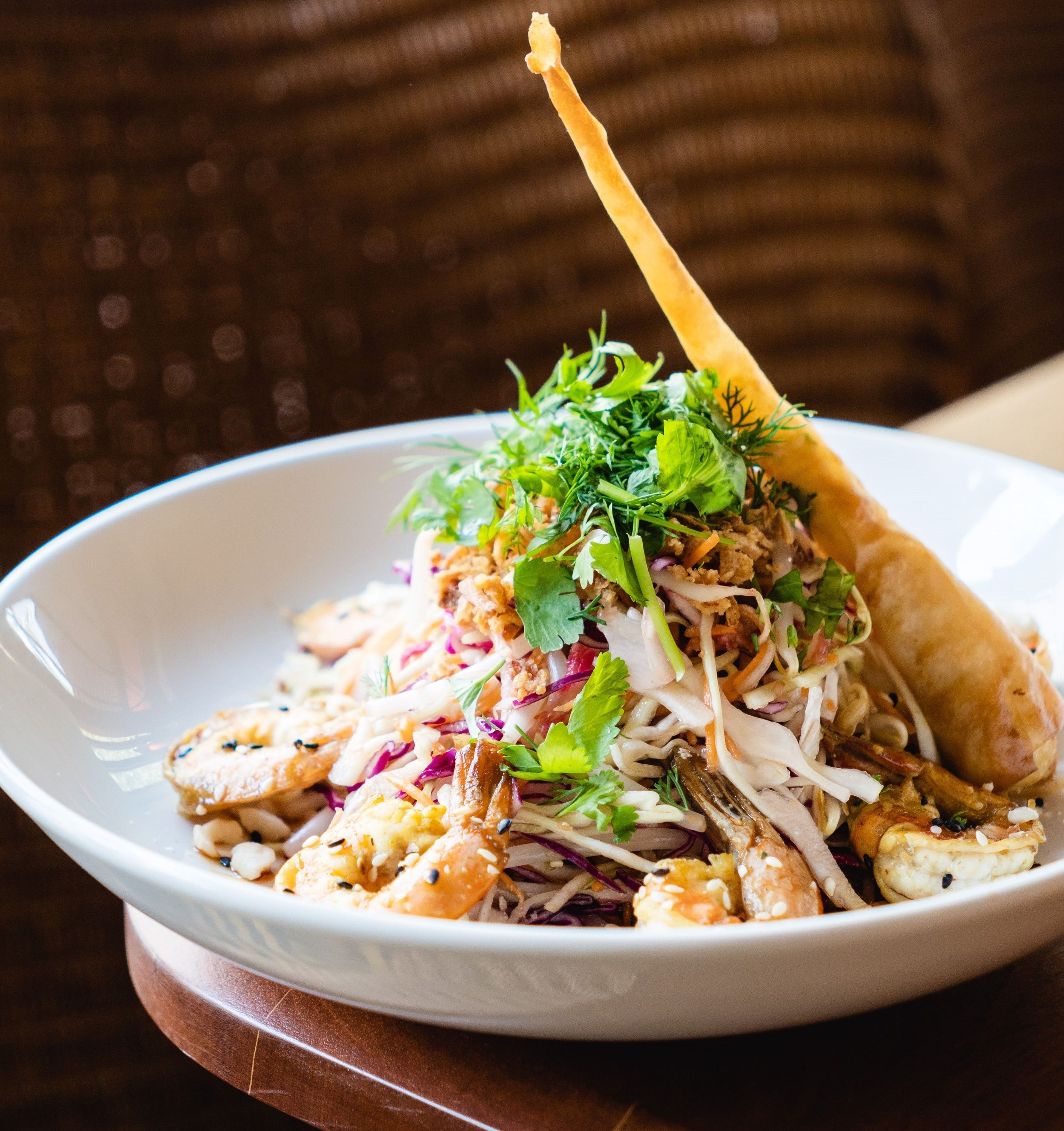 Salade de crevettes garnie d'herbes fraîches, accompagnée d'une tuile croustillante.