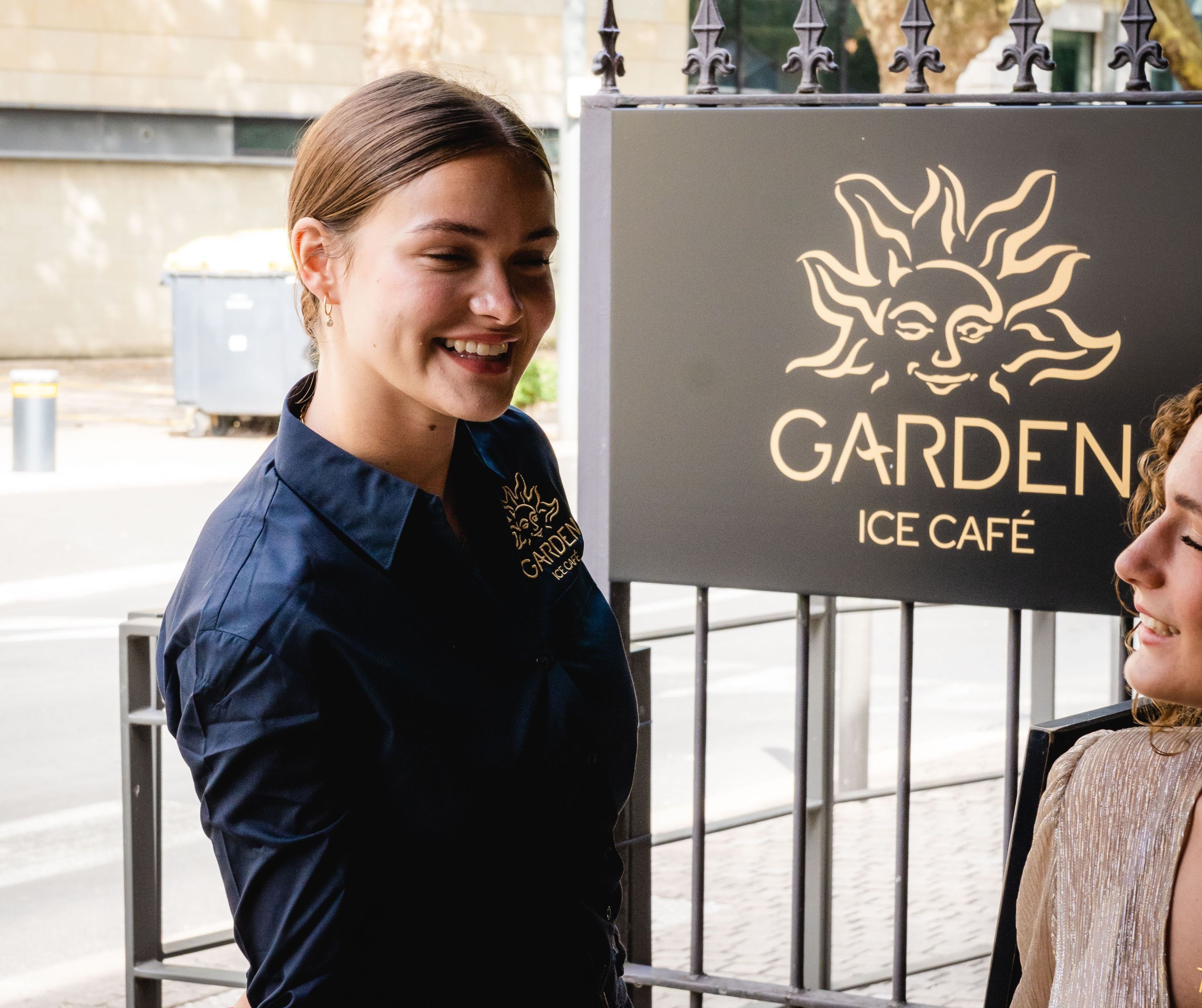Serveuse accueillante à l'extérieur du Garden Ice Café à Périgueux.