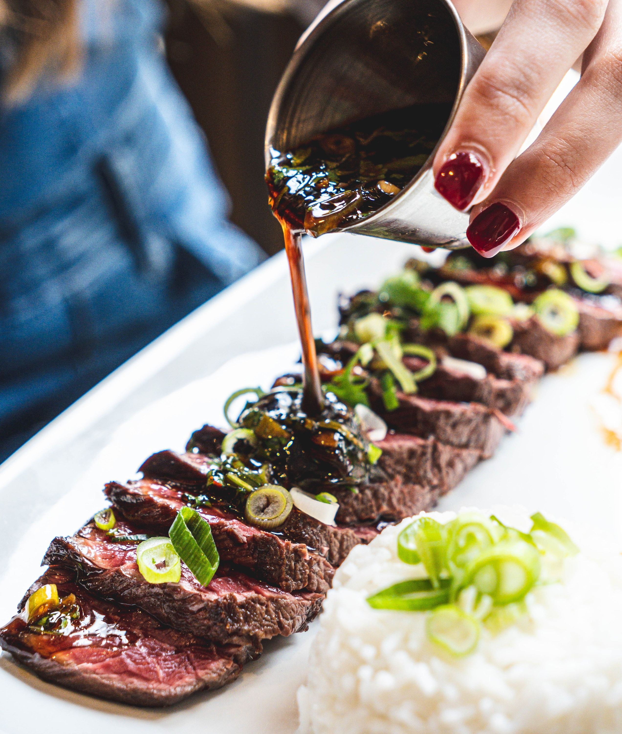 Viande tranchée avec garniture de riz et sauce, présentée dans un cadre de brasserie. Cuisine faite maison.
