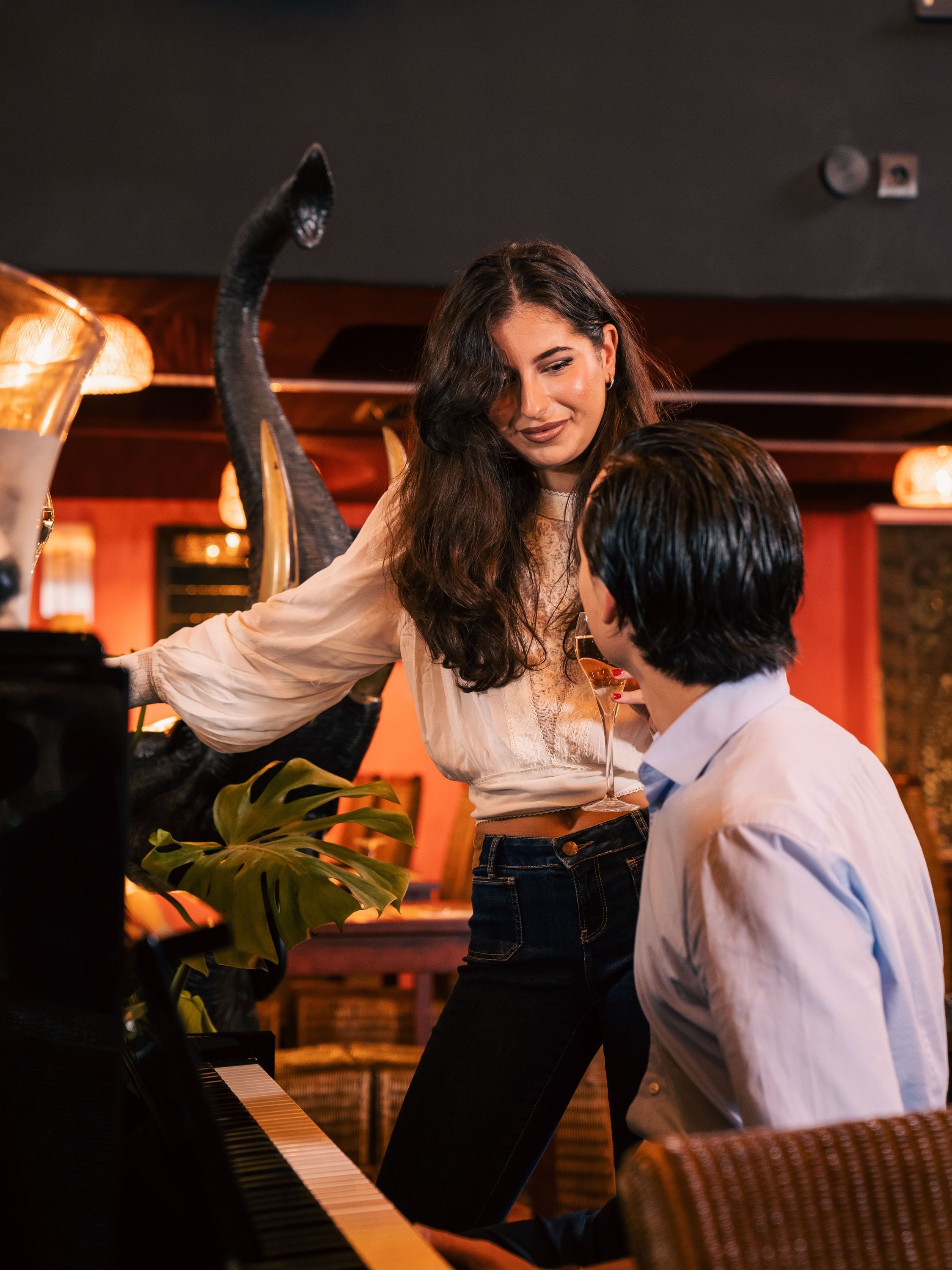 Un couple se détend dans un restaurant avec une ambiance musicale chic, entouré de décorations élégantes.