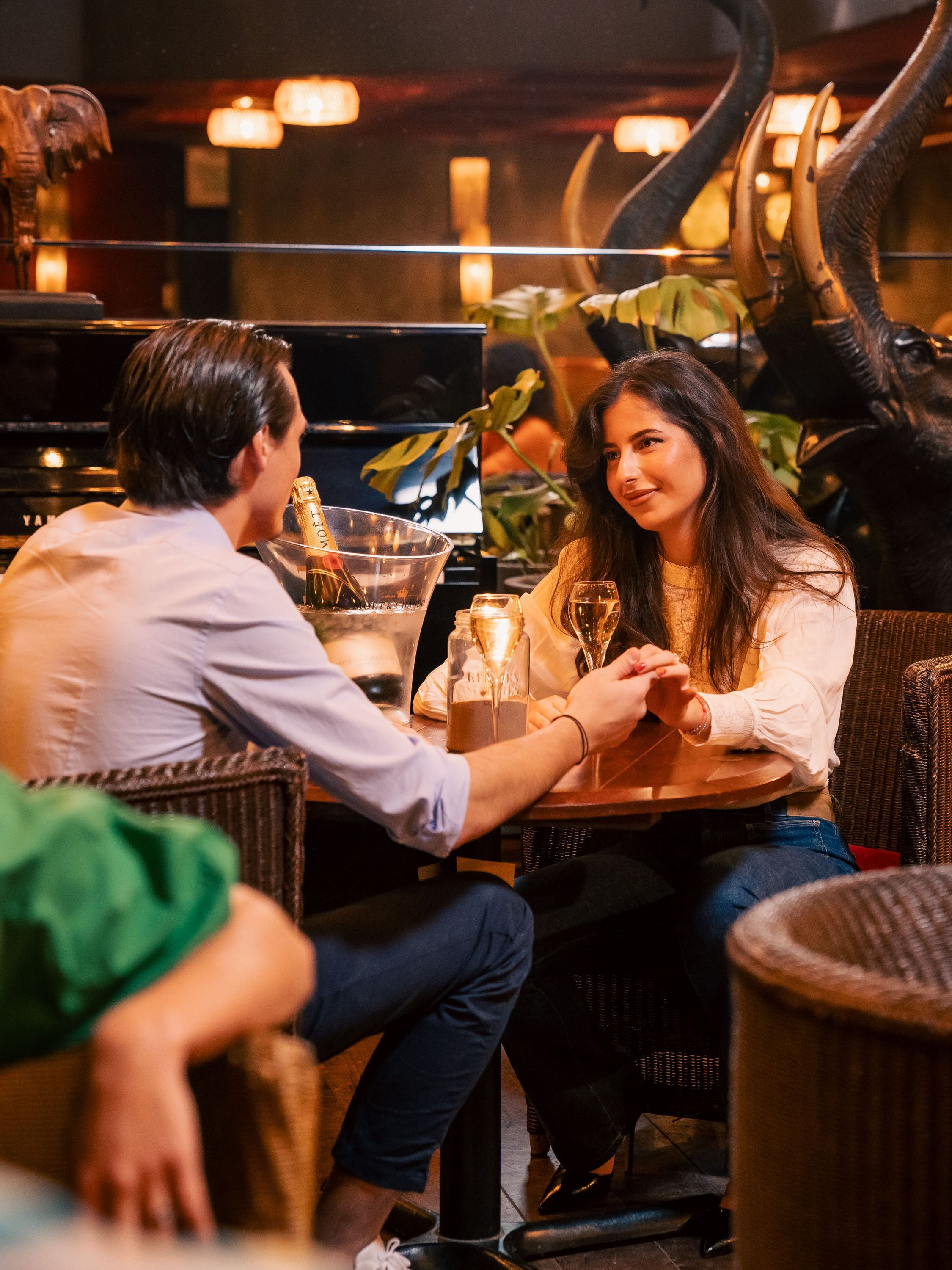 Couple à une table dans une brasserie, service continu, avec ambiance chaleureuse et décor élégant.